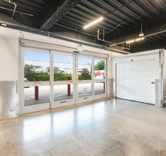 Interior of climate-controlled storage facility with glass doors and metal roll-up unit, Value Store It