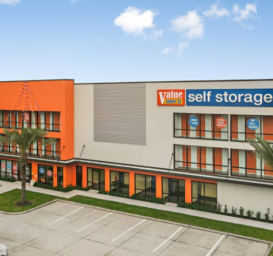 Value Store It self-storage facility exterior with orange and white facade, ground-level units.