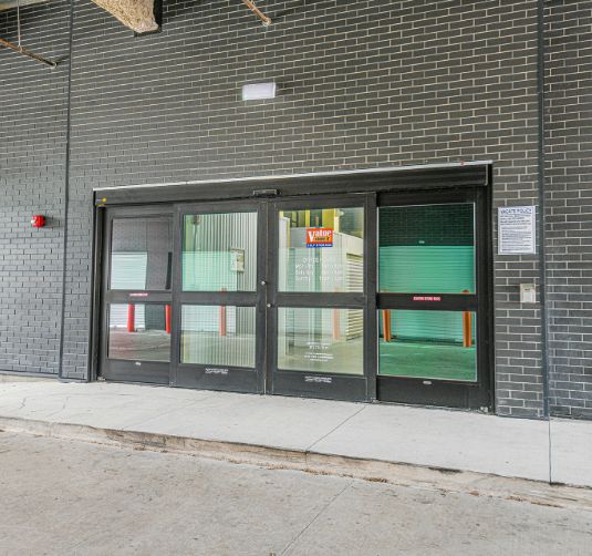 Exterior entrance with green roll-up storage unit doors, Value Store It facility