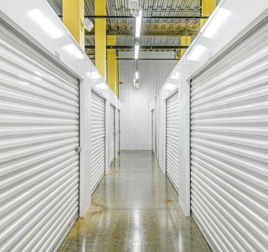 Interior hallway with climate-controlled storage units, bright lighting, polished concrete floor.